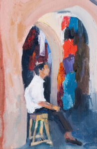 Study of a boy in a shop in Rabat showing the archways.