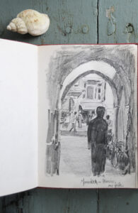 A man under the archway and the busy street farther away